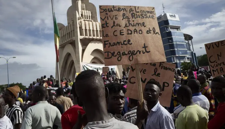 Un homme tient une pancarte indiquant "Soutien à l'armée, vive la Russie et la Chine, la CEDEAO et la France sortent" alors que les partisans du CNSP (Comité national pour le salut du peuple) participent à un rassemblement sur la place de l'indépendance à Bamako, le 8 septembre 2020, à la suite d'un appel du MP4 (Mouvement populaire du 4 septembre) à un rassemblement pour soutenir le rôle de l'armée dans la phase de transition du Mali après le renversement du président par une junte militaire. - Le bloc régional ouest-africain, la CEDEAO, a appelé le 7 septembre la junte militaire malienne, qui a pris le pouvoir le mois dernier, à nommer un civil à la tête d'un gouvernement de transition d'ici le 15 septembre. (Photo de MICHELE CATTANI / AFP)