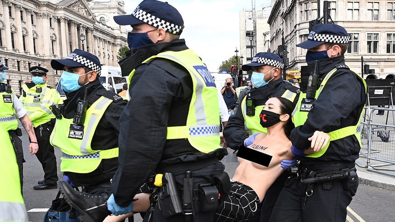 La police enlève une manifestante aux seins nus après qu'elle s'est enfermée aux grilles du Parlement lors d'une manifestation contre le changement climatique @ EPA