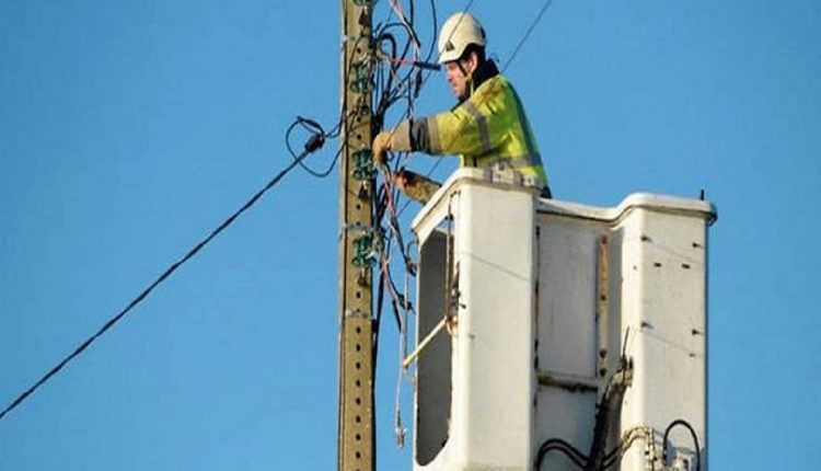 Un technicien de téléphonie sur un poteau travaillant sur une ligne téléphonique en France