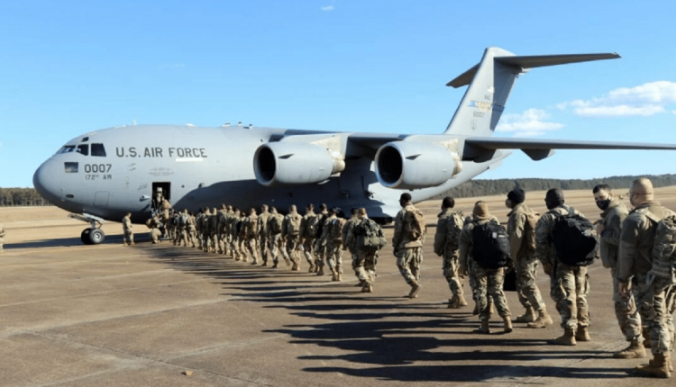 Des soldats de la garde nationale américaine montant dans un avion de trasport de troupe pour rejoindre Washington DC avant l'investiture de Joe Biden