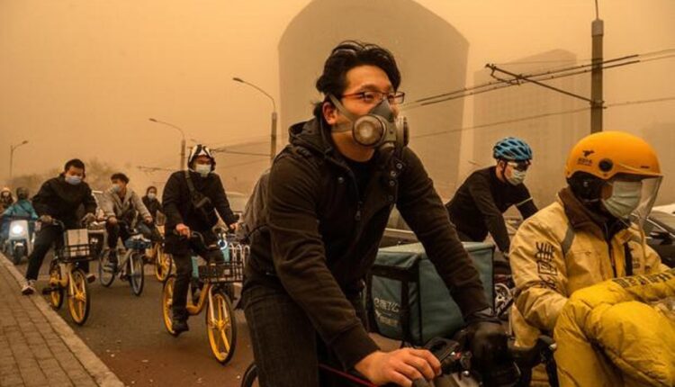 Les usagers portent des masques lorsqu'ils voyagent pendant la tempête de sable à Pékin.