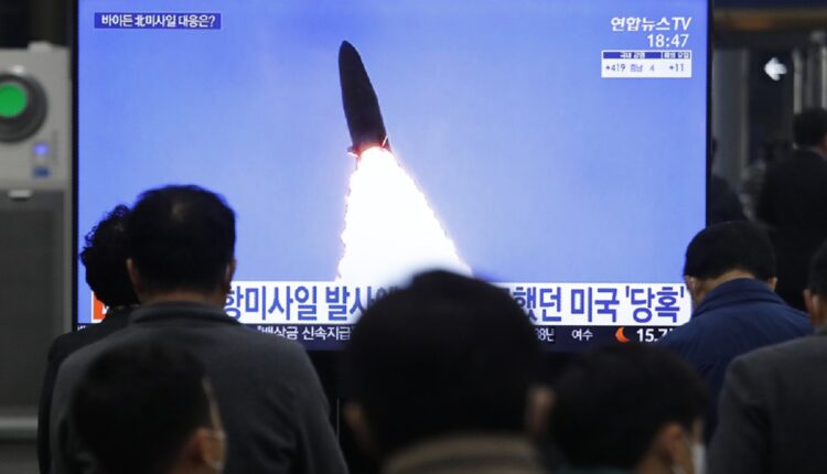 Des responsables nord-coréens regardent le tire d'un missile sur un écran